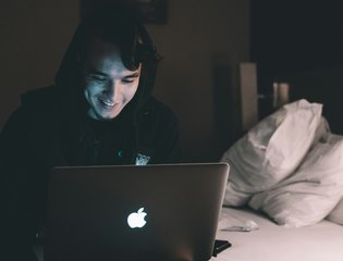 A young person uses a laptop.