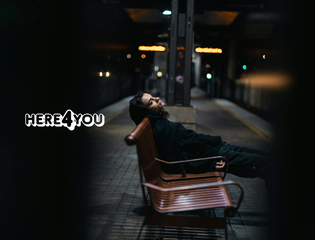 A young person sits on a train station bench alone.