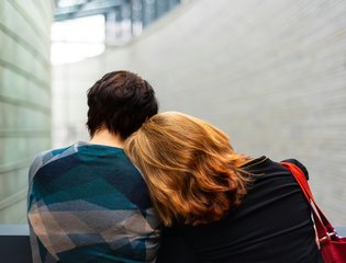 A mum rests her head on her teenage son.