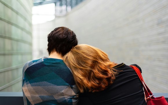 A mum rests her head on her teenage son.